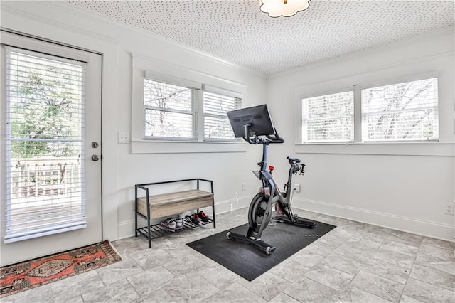 exercise area with baseboards and ornamental molding