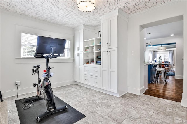 workout room featuring baseboards and crown molding