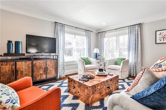 living area featuring a wealth of natural light, baseboards, wood finished floors, and ornamental molding