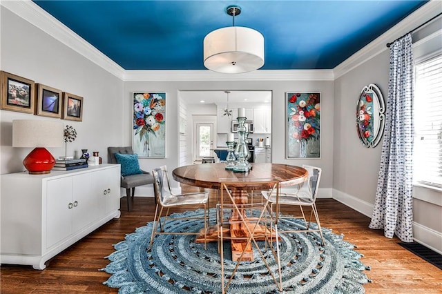 dining area featuring crown molding, baseboards, and dark wood-style flooring