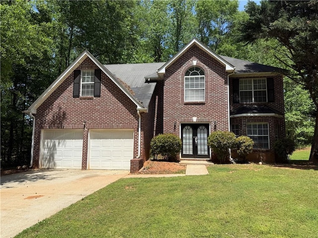 view of front of home featuring french doors, concrete driveway, a front yard, and brick siding