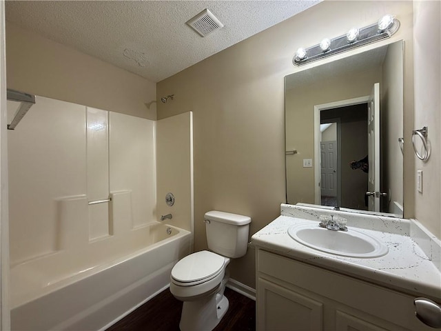 full bathroom with vanity, toilet, a textured ceiling, wood finished floors, and visible vents