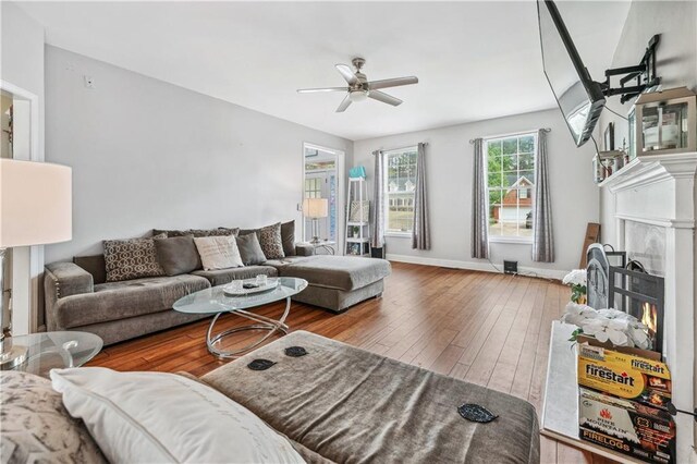 642 Towering Pine Trl, Lawrenceville, GA 30045 - living room with ceiling fan, a lit fireplace, hardwood / wood-style floors, and baseboards