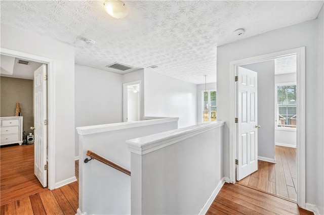 642 Towering Pine Trl, Lawrenceville, GA 30045 - hall with an upstairs landing, hardwood / wood-style floors, baseboards, and a textured ceiling