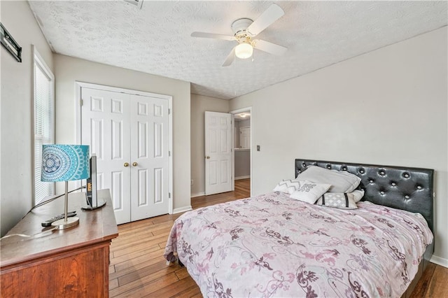 642 Towering Pine Trl, Lawrenceville, GA 30045 - bedroom with wood finished floors, a textured ceiling, ceiling fan, baseboards, and a closet