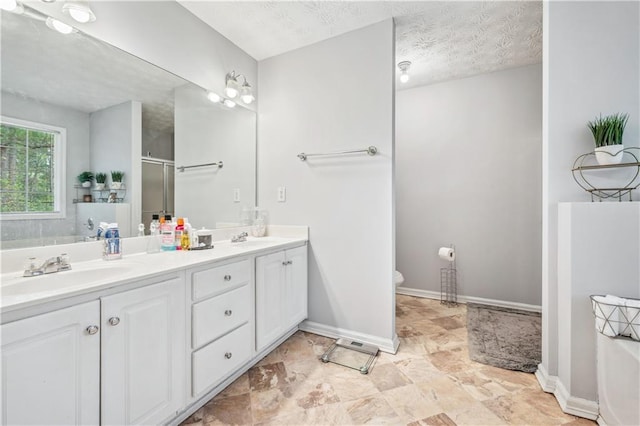 642 Towering Pine Trl, Lawrenceville, GA 30045 - bathroom featuring double vanity, a shower with door, baseboards, a tub to relax in, and a textured ceiling