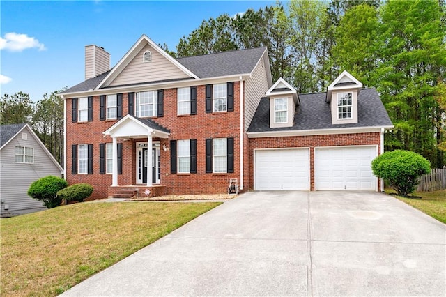 642 Towering Pine Trl, Lawrenceville, GA 30045 - colonial inspired home featuring a chimney, brick siding, an attached garage, and driveway