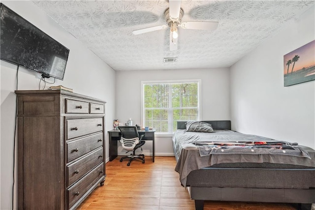 642 Towering Pine Trl, Lawrenceville, GA 30045 - bedroom with light wood-style flooring, ceiling fan, baseboards, a textured ceiling, and a desk