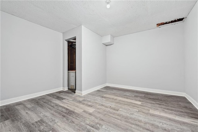 642 Towering Pine Trl, Lawrenceville, GA 30045 - spare room with wood finished floors, a textured ceiling, and baseboards