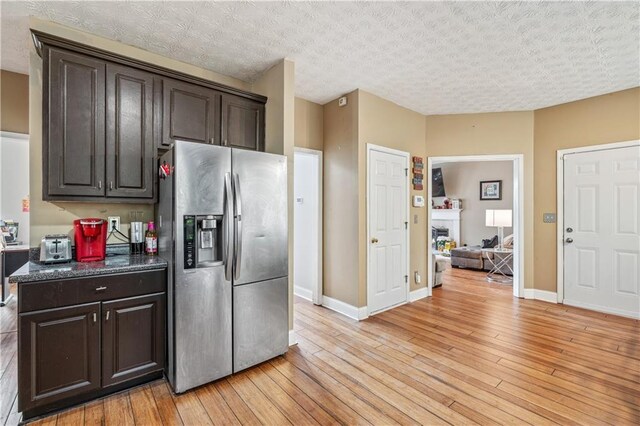 642 Towering Pine Trl, Lawrenceville, GA 30045 - kitchen with stainless steel fridge, dark brown cabinetry, light wood-style floors, and baseboards
