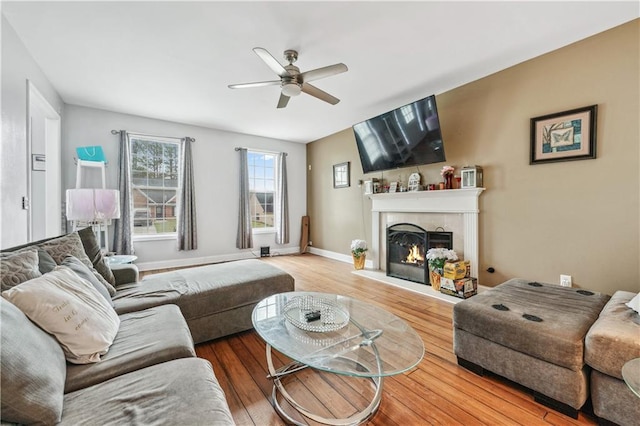642 Towering Pine Trl, Lawrenceville, GA 30045 - living area featuring a ceiling fan, wood finished floors, a warm lit fireplace, and baseboards