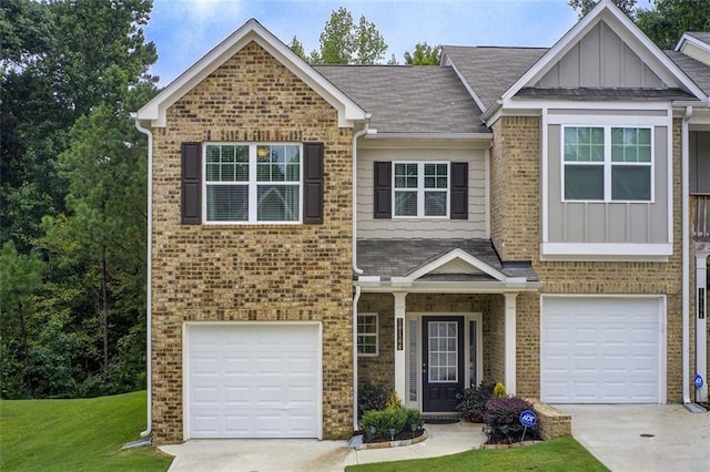 view of front facade featuring a garage, brick siding, driveway, a front lawn, and board and batten siding