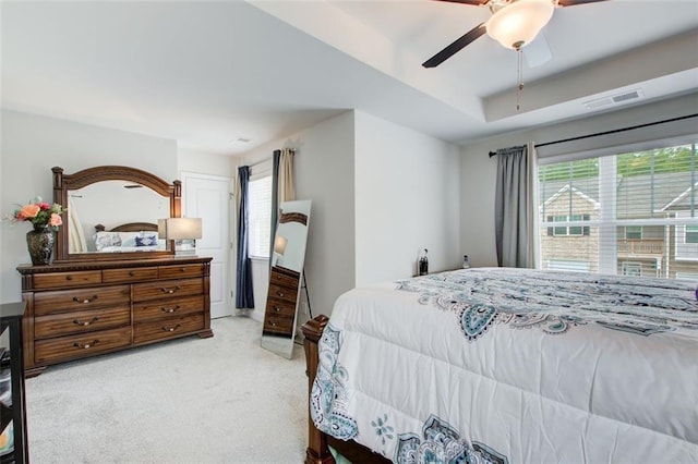 bedroom featuring carpet floors, multiple windows, visible vents, and a ceiling fan