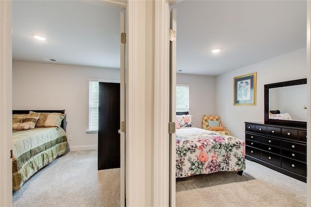 carpeted bedroom featuring baseboards and recessed lighting