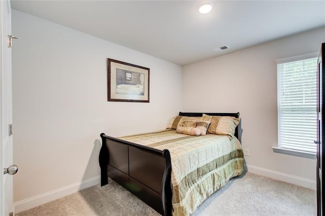 carpeted bedroom with visible vents, baseboards, and multiple windows