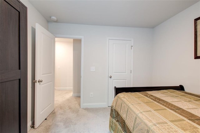 bedroom with light carpet and baseboards