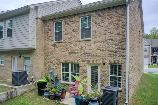 back of house featuring cooling unit, a patio, and brick siding