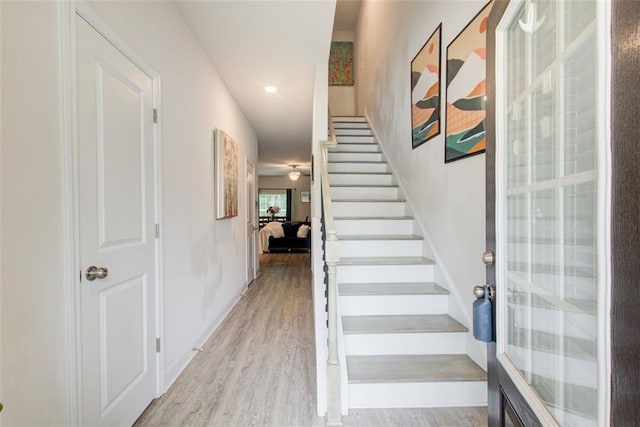 stairs featuring wood finished floors and baseboards