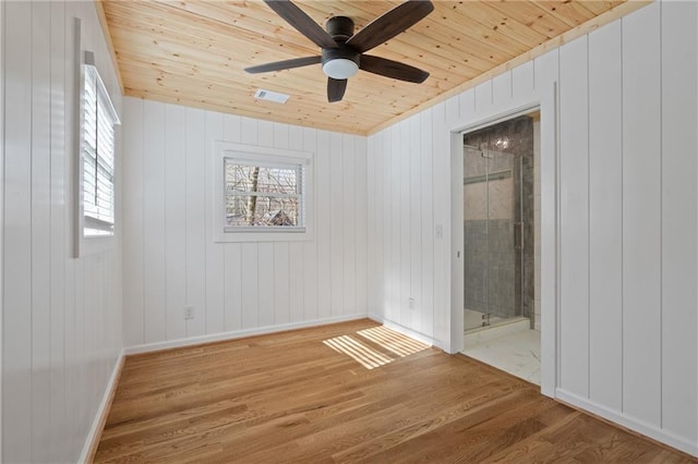 unfurnished bedroom featuring baseboards, wooden ceiling, wood finished floors, and multiple windows
