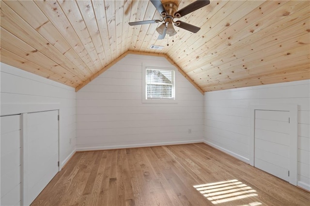 additional living space with baseboards, lofted ceiling, light wood finished floors, and visible vents