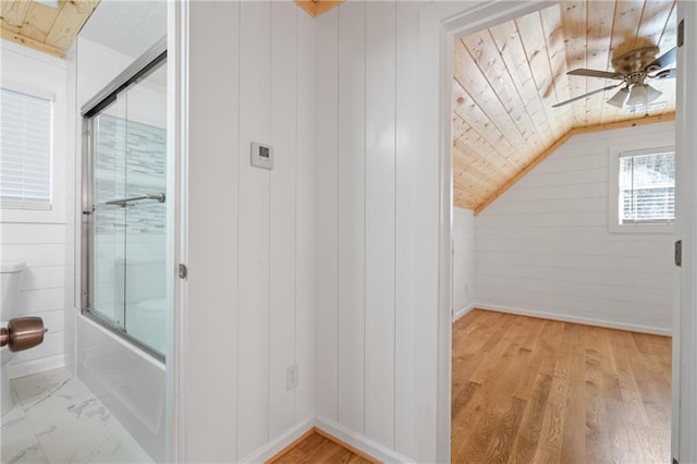additional living space featuring wooden walls, ceiling fan, baseboards, wooden ceiling, and lofted ceiling
