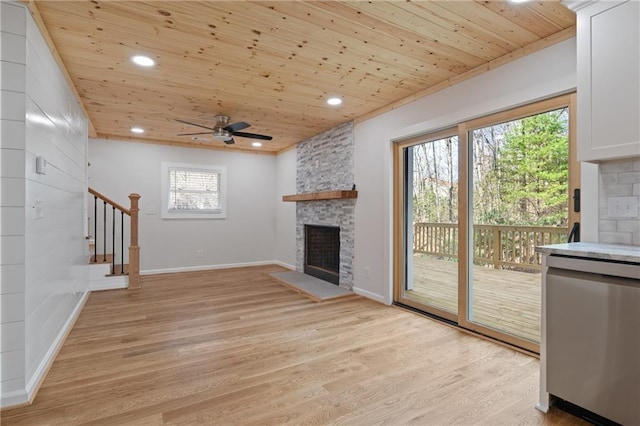 unfurnished living room with stairway, wooden ceiling, light wood-type flooring, a fireplace, and ceiling fan