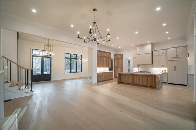 bar with light stone countertops, light hardwood / wood-style floors, and sink