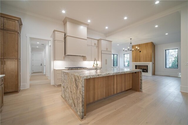 unfurnished living room featuring light wood-type flooring, an inviting chandelier, and sink