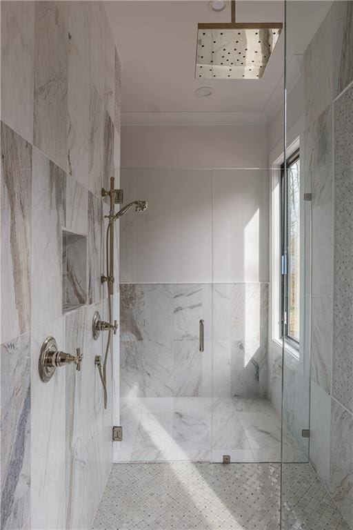 bathroom featuring a healthy amount of sunlight, a shower with shower door, and ornamental molding