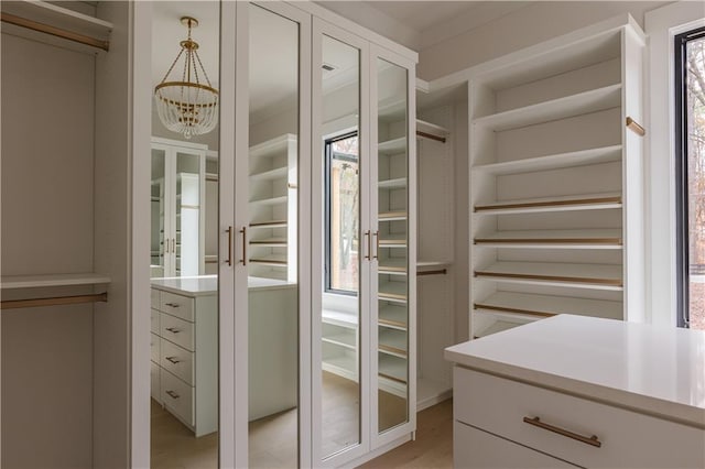 spacious closet with an inviting chandelier