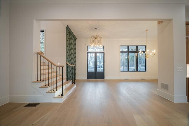 stairway featuring wood-type flooring and an inviting chandelier