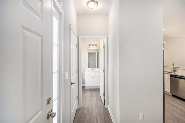 corridor featuring light hardwood / wood-style floors and sink