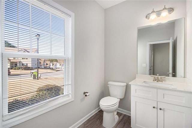 bathroom with toilet, vanity, and hardwood / wood-style flooring