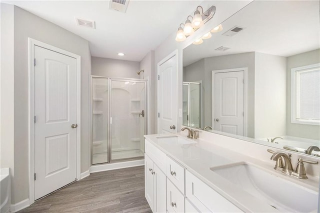 bathroom featuring independent shower and bath, hardwood / wood-style floors, and vanity