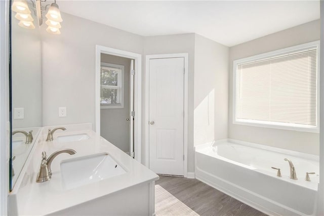 bathroom featuring vanity, a washtub, a chandelier, and hardwood / wood-style flooring