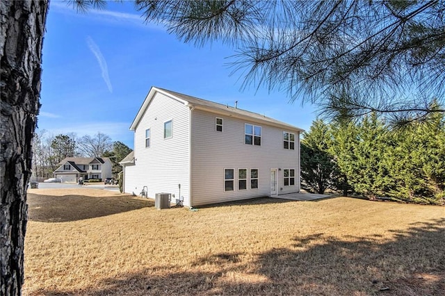 back of property featuring a lawn and cooling unit