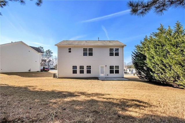 rear view of property featuring a yard and a patio area