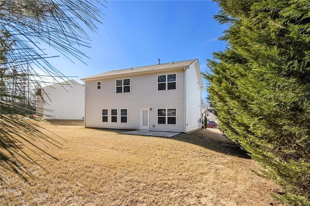 rear view of property with a yard and a patio area