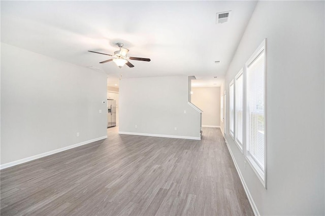 unfurnished room with ceiling fan, plenty of natural light, and wood-type flooring