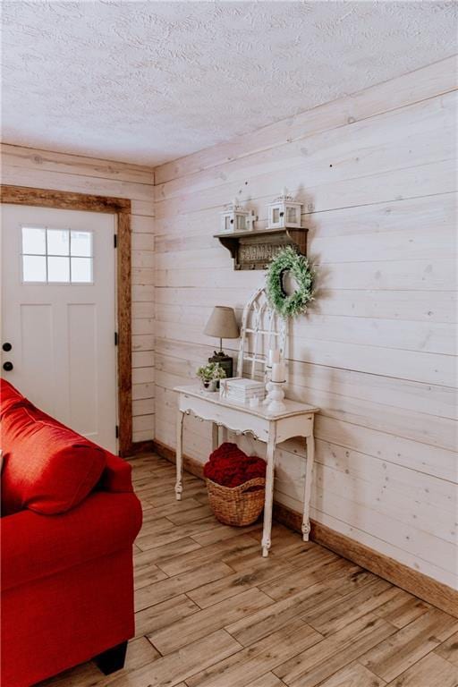 4625 Ben Hill Dr, Oakwood, GA 30566 - foyer featuring a textured ceiling, baseboards, light wood-style flooring, and wood walls