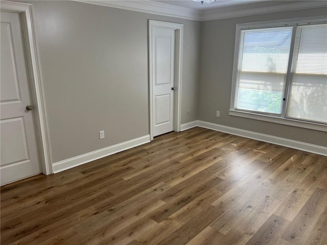 unfurnished room featuring dark hardwood / wood-style flooring, crown molding, and a notable chandelier