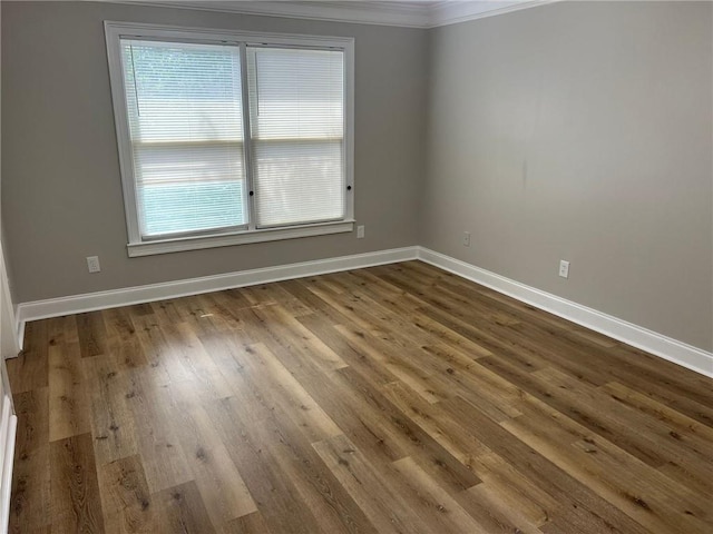 spare room with hardwood / wood-style floors and crown molding