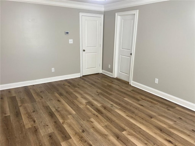 empty room featuring dark hardwood / wood-style flooring and crown molding