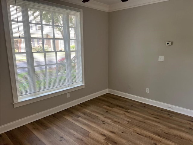 empty room with dark wood-type flooring, ceiling fan, and ornamental molding