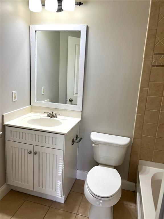 bathroom with tile patterned flooring, vanity, and toilet