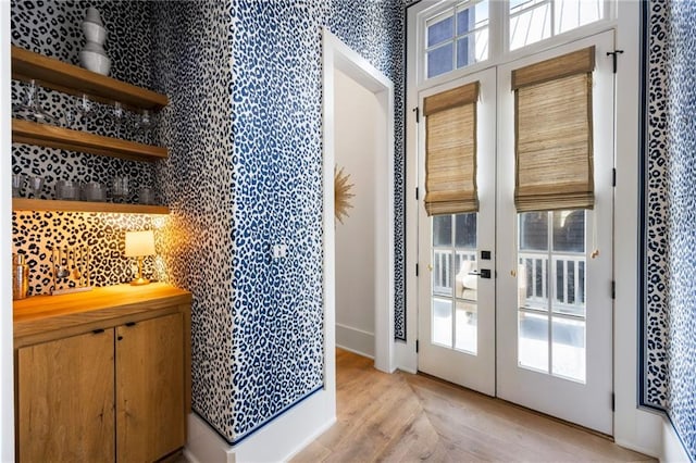 doorway with french doors and wallpapered walls