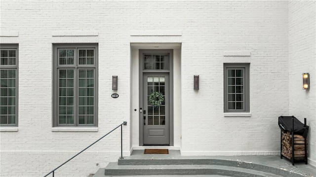 doorway to property featuring brick siding