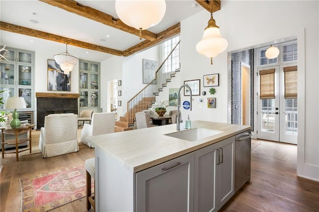 kitchen featuring gray cabinets, french doors, wood finished floors, and a sink