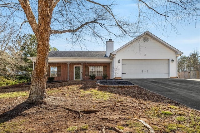 ranch-style house featuring driveway, a garage, a chimney, and brick siding