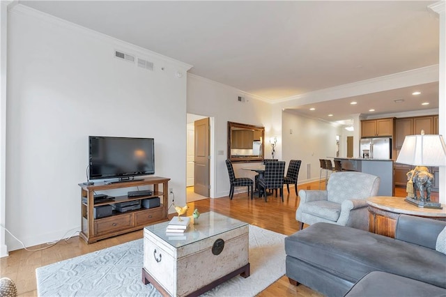 living room featuring ornamental molding and light wood-type flooring